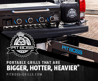 A portable Pit Boss table top charcoal grill sitting in a pickup truck bed with the tailgate down.