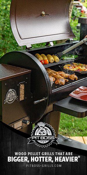 Person using tongs to check the food being cooked on a Pit Boss wood smoked grill at an outdoor party.