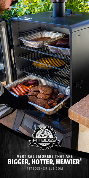 Hamburgers and hot dogs cooking outside in a Pit Boss vertical smoker.